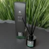 100ml glass reed diffuser bottle labelled “Revive”, accompanied by natural reeds and presented on a clean surface. The design is minimalist and elegant, with a subtle Welsh-made branding visible.